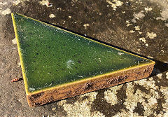 A green glazed triangular tile from J C Edwards, Ruabon, Denbighshire © Photo courtesy of Ian Evans